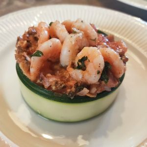 Gamba's op een frisse salade in een ring van gerookte courgette